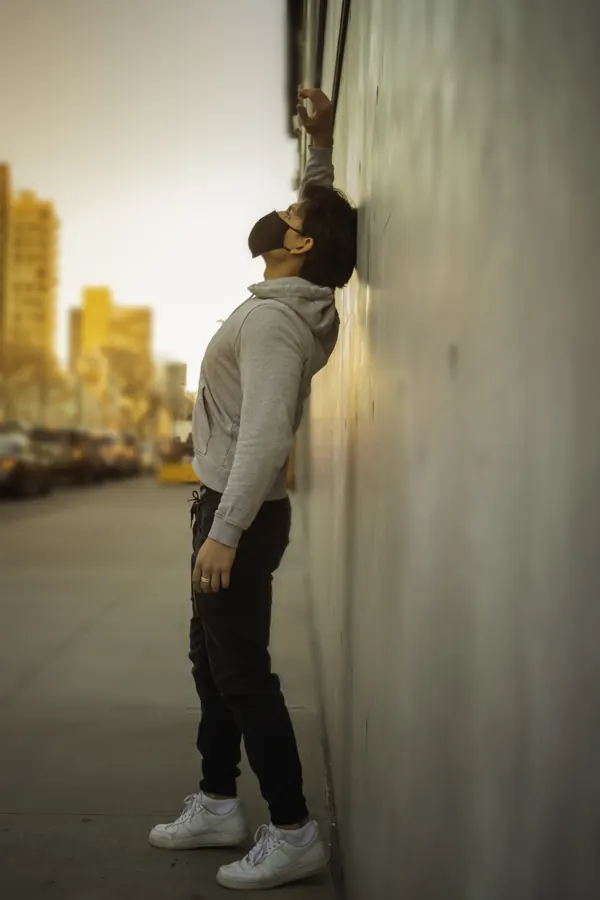 Man leaning against a wall and looking up