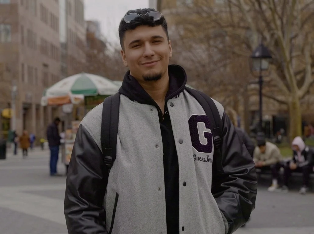 Omar Fasli in a varsity jacket in a New York park