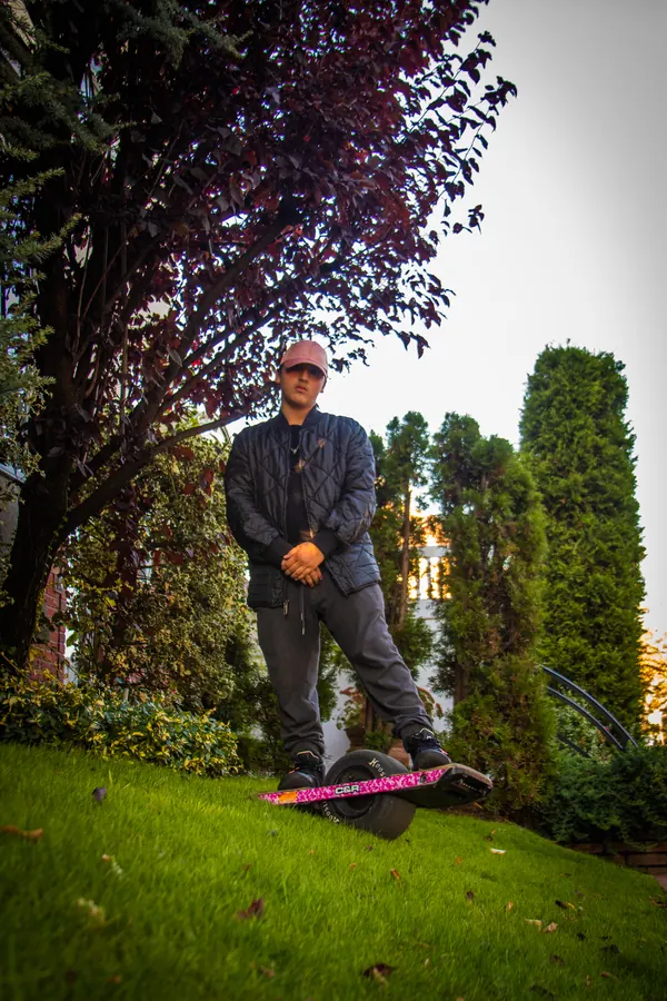 Man riding a onewheel board on a lawn