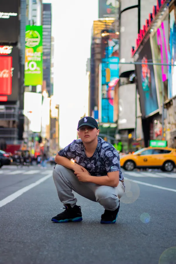 Man crouching in the middle of Times Square