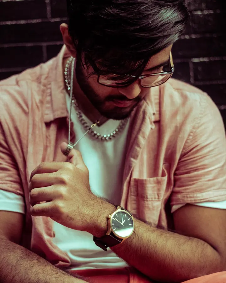 Man in a striped shirt adjusting his watch